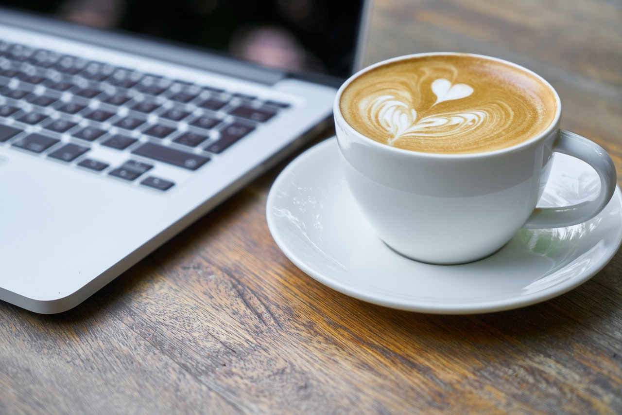 An image of a coffee cup and laptop to talk about marketing I provide for wellness businesses to do their marketing themselves.